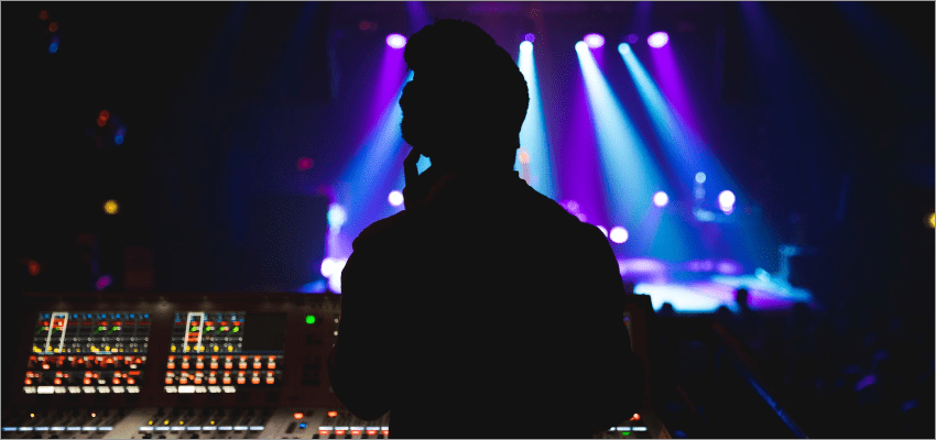 Silhouetted production operator at a concert control console